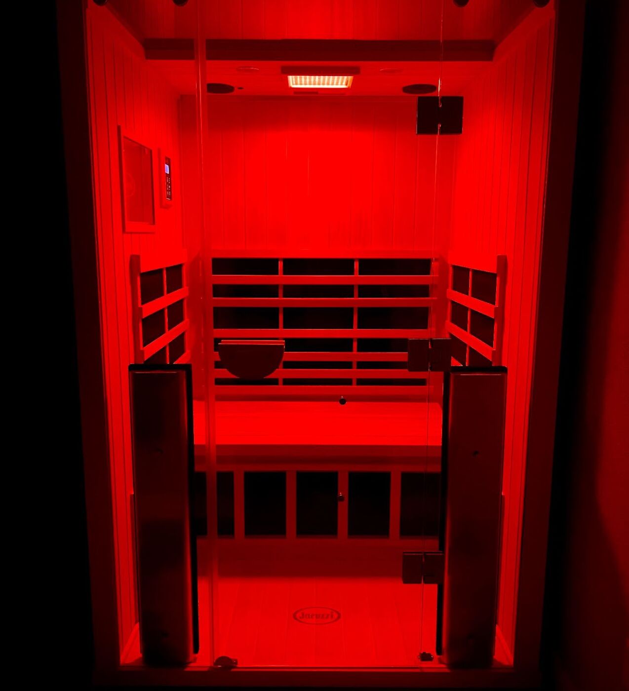 Private infrared sauna glowing with red chromotherapy light